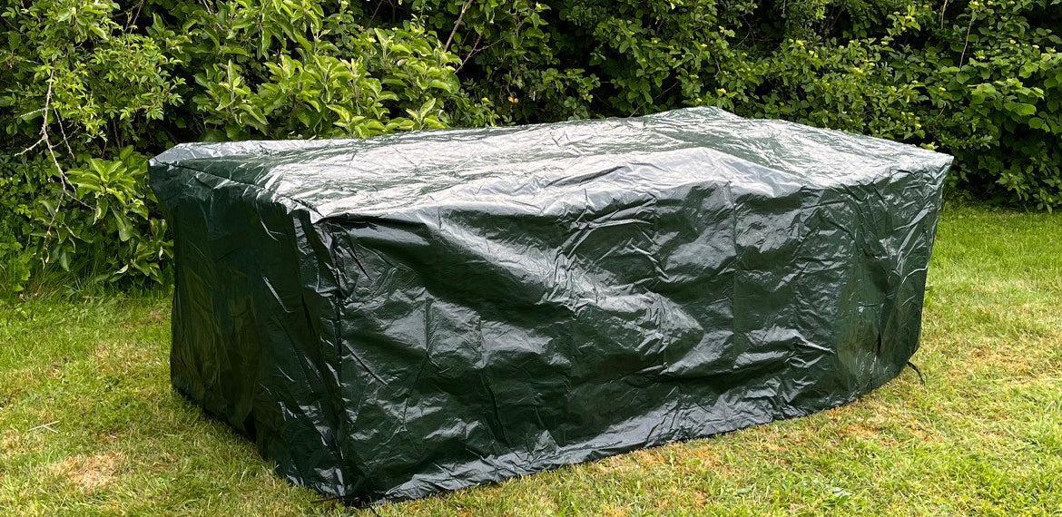 Green rectangular cover on a grassy area with trees in the background