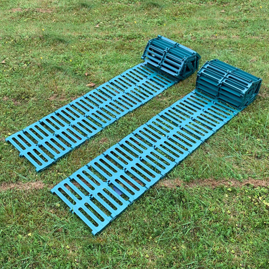 A green plastic garden track path laid out on grass, consisting of multiple connected panels.