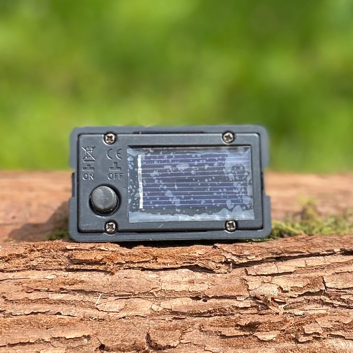 A solar-powered white LED light box placed on a wooden surface, featuring a waterproof on/off switch.