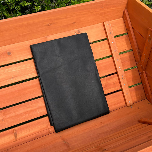 A black liner for a medium veg trough planter laid out on a wooden surface.