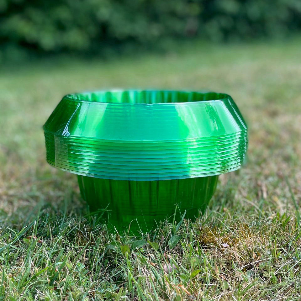 A pack of green plastic slug and snail plant protection collars placed on grass.
