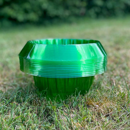 A pack of green plastic slug and snail plant protection collars placed on grass.