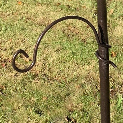 A hammertone finished metal hanging bracket hook with a spiral fixing, attached to a pole outdoors.