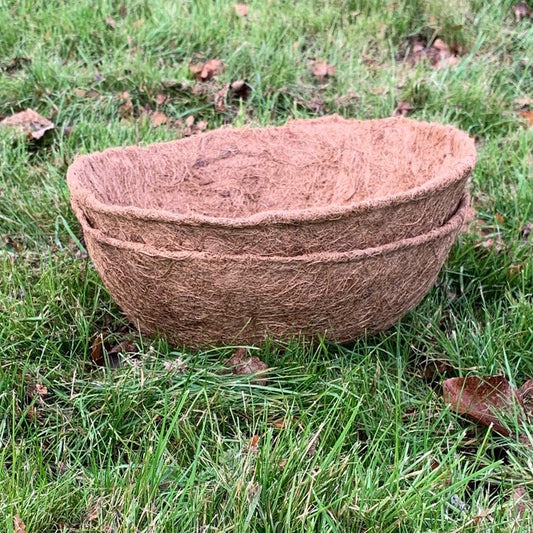 Two brown coco hanging basket planter liners placed on grass.