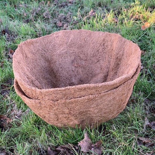 Two brown coco hanging basket planter liners placed on grass.