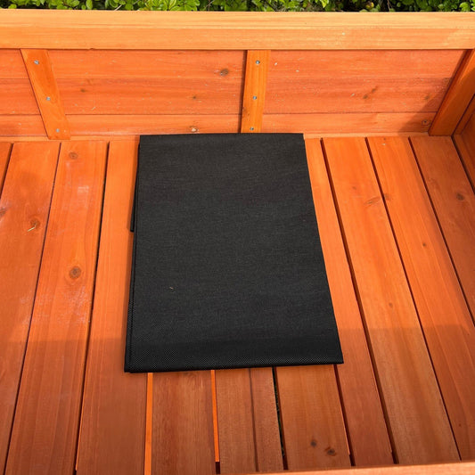 A black liner placed inside a wooden raised herb planter.