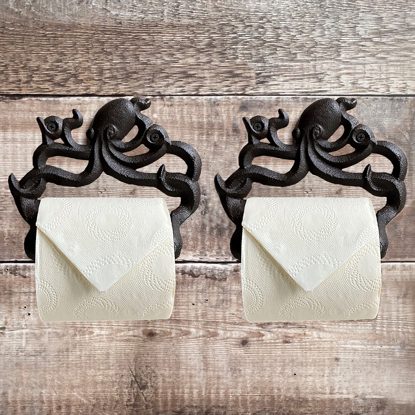 Two wall mounted cast iron octopus shaped loo roll holders against a wooden background, holding white toilet paper.