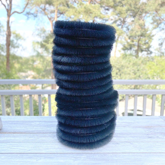 Stack of black gutter protection brush ties on a table with a blurred outdoor background