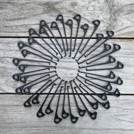 Set of gutter clips arranged in a circular pattern on wooden surface