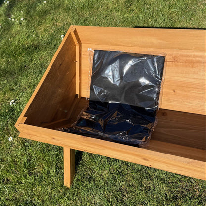 Wooden planter with a black liner inside on grass