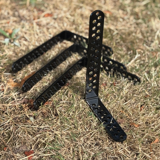 Black metal plant trellis on dry grass